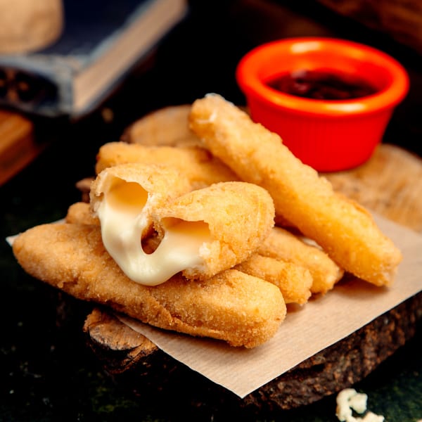 Golden-fried mozzarella sticks with melted cheese oozing out, served with a red dipping sauce.